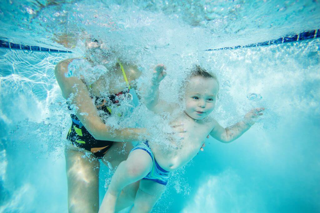 Young woman and little boy in swimming pool