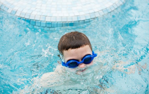 Kid in a swimming pool surfacing out of water